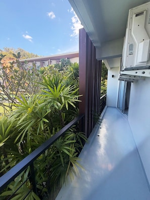 A balcony with a view of a building and greenery. - Spacious & Stylish 2-Bedroom Condo at Replay Residence – Bo Phut (Koh Samui)