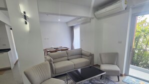 Un salon moderne avec un canapé, un fauteuil et une table basse.