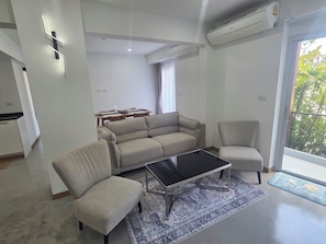 Uma sala de estar moderna com sofá, poltrona e mesa de centro.