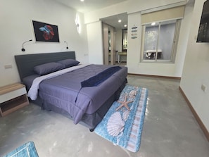 Quarto com cama, mesa de cabeceira e um tapete decorativo.