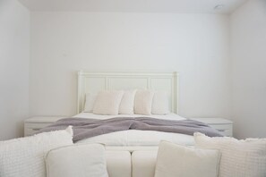 A bedroom with a bed, white nightstands, and a white headboard. - 5 BR Solterra Resort w Private Heated Pool (Davenport)
