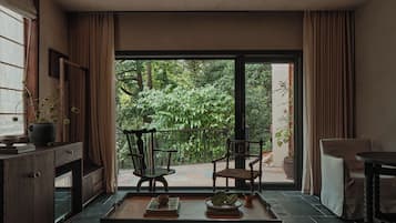 A room with a large sliding glass door leading to a balcony with two chairs and a table.