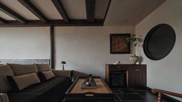 A modern living room with a dark sofa, a wooden coffee table, and a dark wooden cabinet.