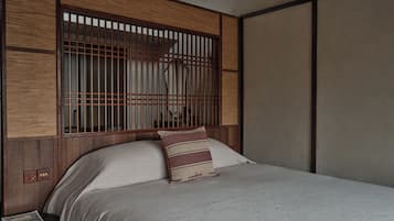 A room with a bed, wooden headboard, and a nightstand with a book.