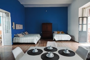 A room with two beds, a wooden wardrobe, a table with cups, and a view through a window. - Vrbo Property (Heroica Puebla de Zaragoza)