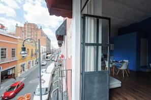 A room with a view of a street, a dining area, and a balcony with a railing. - Vrbo Property (Heroica Puebla de Zaragoza)