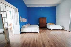 A bedroom with two beds, a wardrobe, and a mirror. - Vrbo Property (Heroica Puebla de Zaragoza)