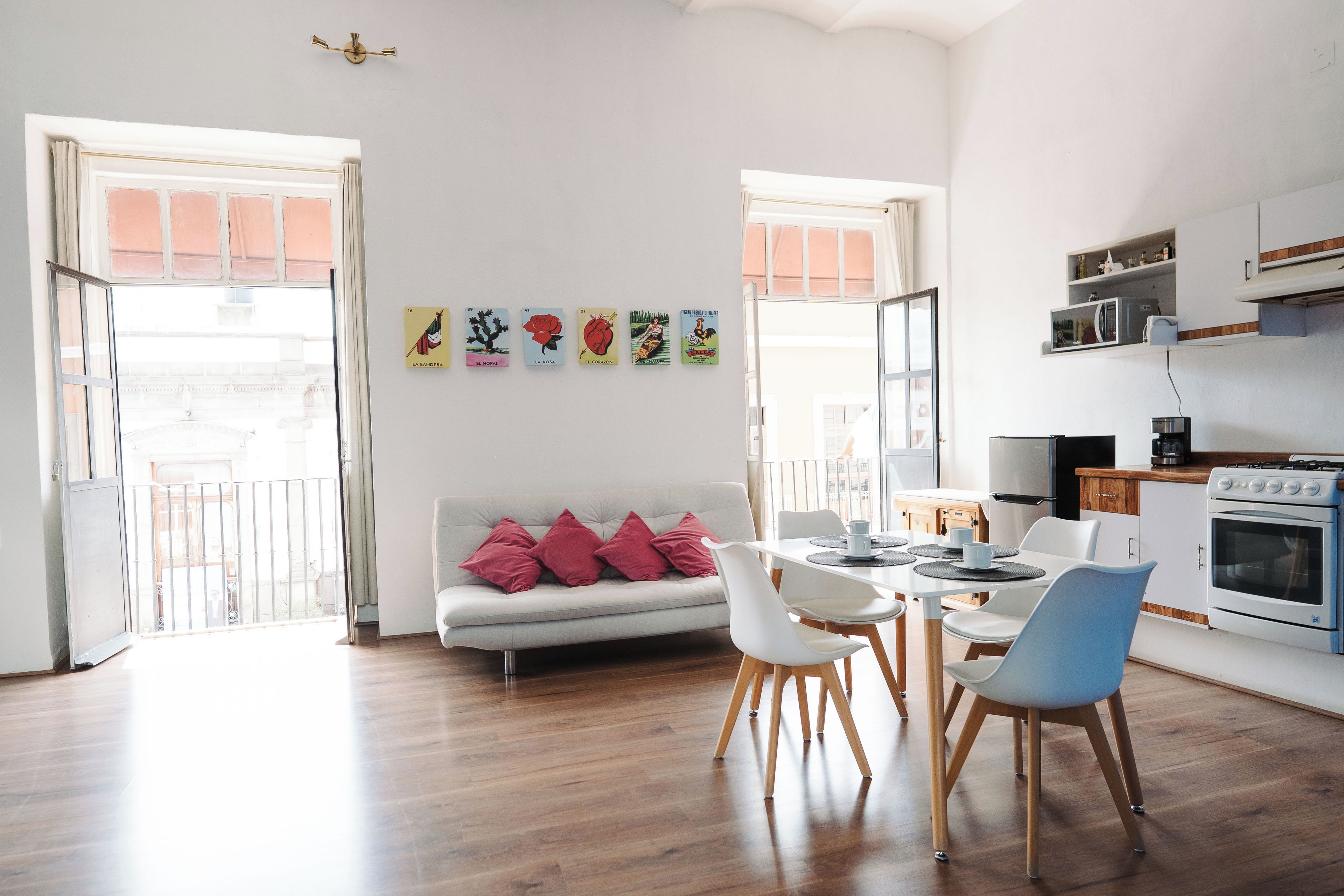 A modern kitchen with white cabinets, a stove, and a microwave.