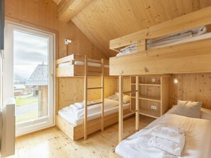 Eine Holzhütte mit Etagenbetten und einem Fenster mit Blick.