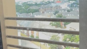 A balcony with a metal railing, overlooking a residential area with houses and greenery. - By GALLERIA near NGR King bedroom Condo. Library, Swimming Pool, Gym, Garden BBQ (Houston)