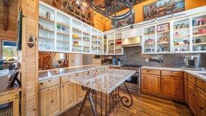 A modern kitchen with wooden cabinets, granite countertops, and a central island. - Dancing Bear Lodge, Pine AZ; Luxury Cabin with Views, Spa & Outdoor living area (Pine)