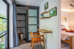A room with a bed, a desk with a chair, a window with curtains, and a wall-mounted shelf with pictures. - 3 Bed Jungle View in Bang Por (KBR64) (Koh Samui)