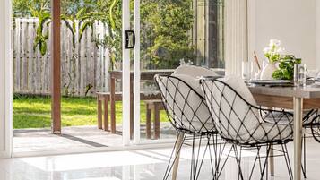 Ein moderner Essbereich mit Glastür zum Garten, Deckenventilator und Tisch für zwei Personen.