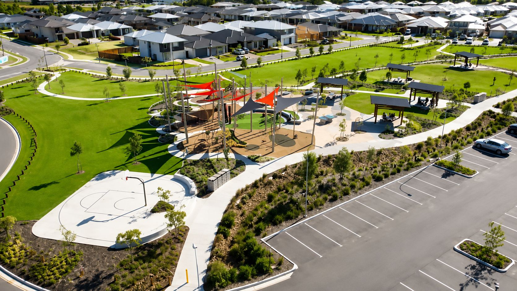 An aerial view of a residential area with modern houses, a playground, and a parking lot.