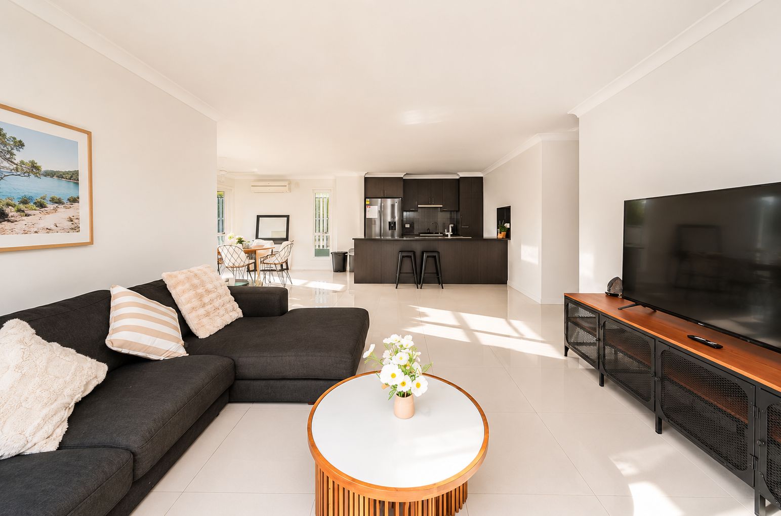 A modern living room with a sofa, a coffee table, and a TV.
