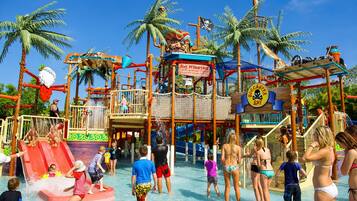 A water park with slides, a pirate-themed play area, and palm trees.