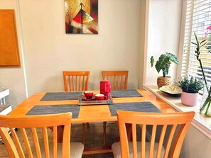 A dining area with a wooden table, four chairs, a red coffee pot, and a painting on the wall. - Cozy & Clean 3BR | 1PK | Spacious, Private Entry (Richmond)