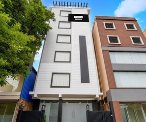 Un edificio de varios pisos con un letrero que indica 'PALETTE' y 'OYO-Serviced' en la fachada.