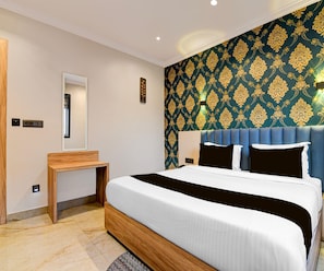 Een hotelkamer met een bed, nachtkastje, spiegel en een muur met behang met een patroon.