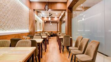 A restaurant interior with wooden walls, brick accents, and a long counter with chairs.