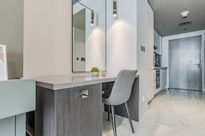 Et moderne køkken med en grå bordplade, et indbygget komfur og en ståldør.
