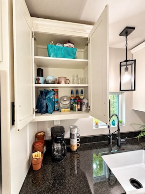 Una cocina con un mueble empotrado, una cafetera y un lavabo.