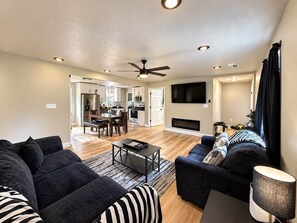 A modern living room with a sofa, coffee table, and a fireplace.