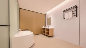 Ein modernes Badezimmer mit einer freistehenden Badewanne, einem Waschtisch mit Spiegel und einem Handtuchhalter.