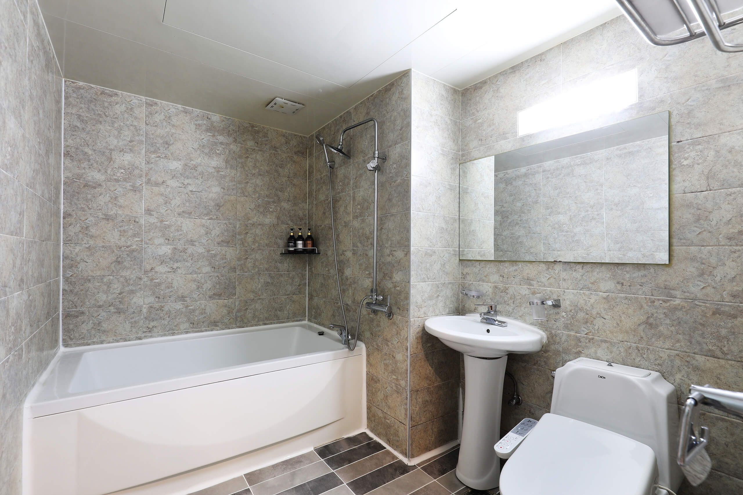 Een moderne badkamer met een bad, een wastafel en een toilet.