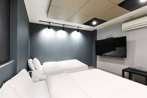 Un dormitorio moderno con una cama grande, un televisor de pantalla plana montado en la pared y una lámpara empotrada en el techo.
