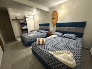 Ein Hotelzimmer mit zwei Betten, einem Schrank, einem Nachttisch und einer Wand-Klimaanlage.