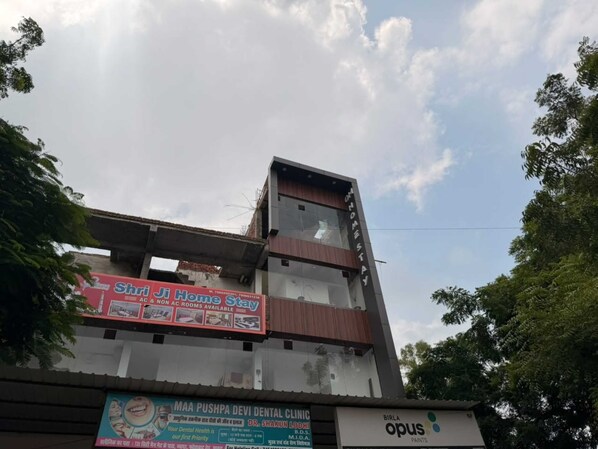 A building with a sign for 'Shriji Home Stay' advertising AC and non-AC rooms. - Om Home Stay (Agra)
