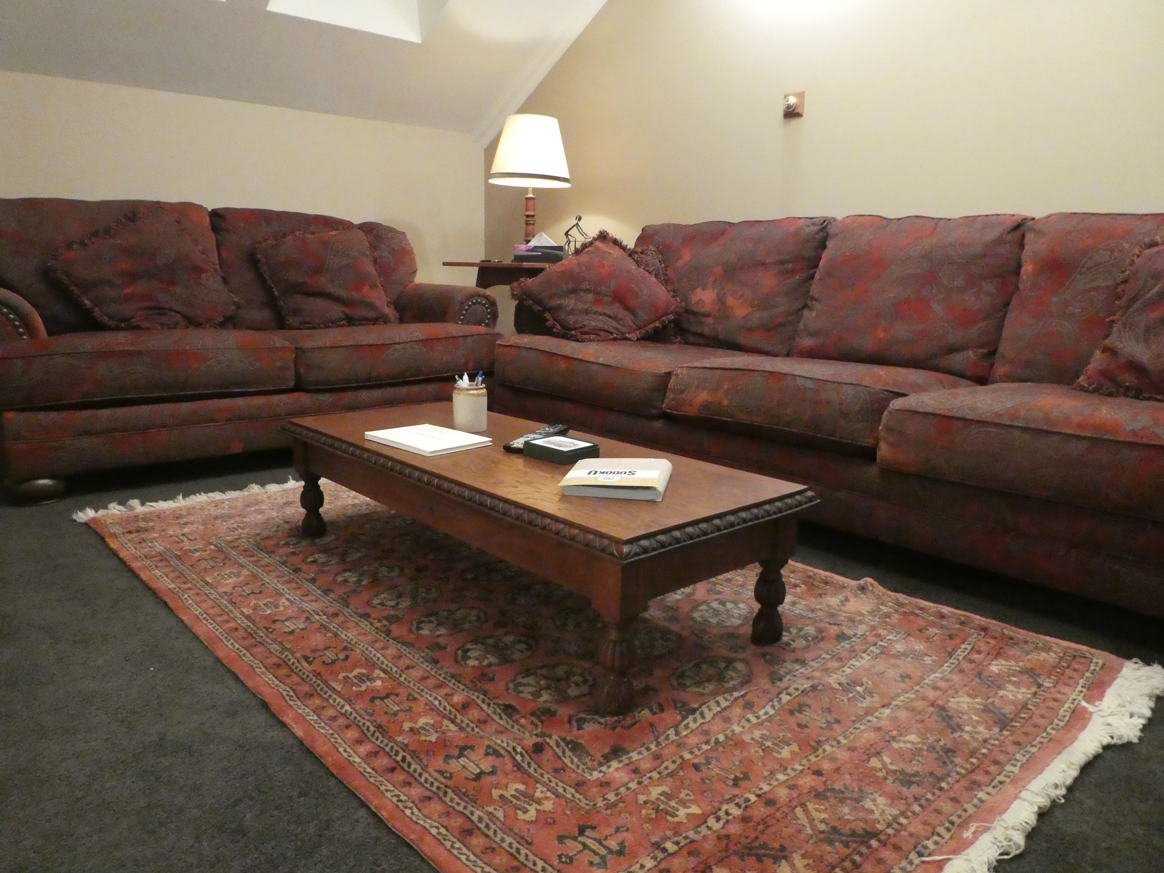 A living room with two sofas, a coffee table, and a patterned rug.