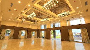 A spacious hall with a high ceiling, large chandeliers, and multiple windows. - Nandankanan Hotel & Resorts  (Lohar Pipalya)