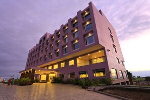 Ein mehrgeschossiges Hotel mit einer flachen Fassade, großen Fenstern und einem gut beleuchteten Eingang.