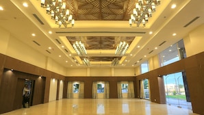 A spacious hotel lobby with a high ceiling, large windows, and a central chandelier. - Nandankanan Hotel & Resorts  (Lohar Pipalya)