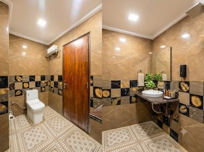 A bathroom with a toilet, sink, and shower area. - NEU VILLA (New Delhi)