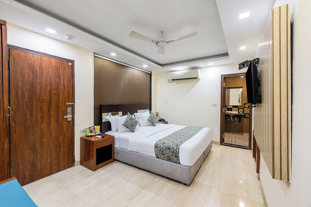 A hotel room with a bed, bedside table, and a wardrobe.