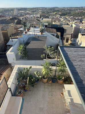 A rooftop terrace with potted plants and a view of the cityscape. - Casa Caprifoglio Noto two terraces (Noto)