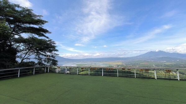 A terrace with a view of a mountain range and a river.