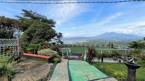 A staircase leading to a viewing platform with a scenic view of a landscape and a mountain in the distance.