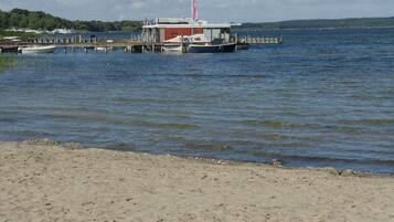 A waterfront property with a dock, a small building, and a boat.