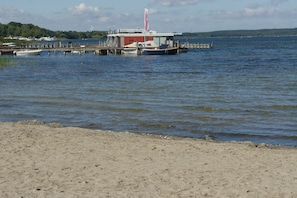 A waterfront property with a dock, a small building, and a boat.