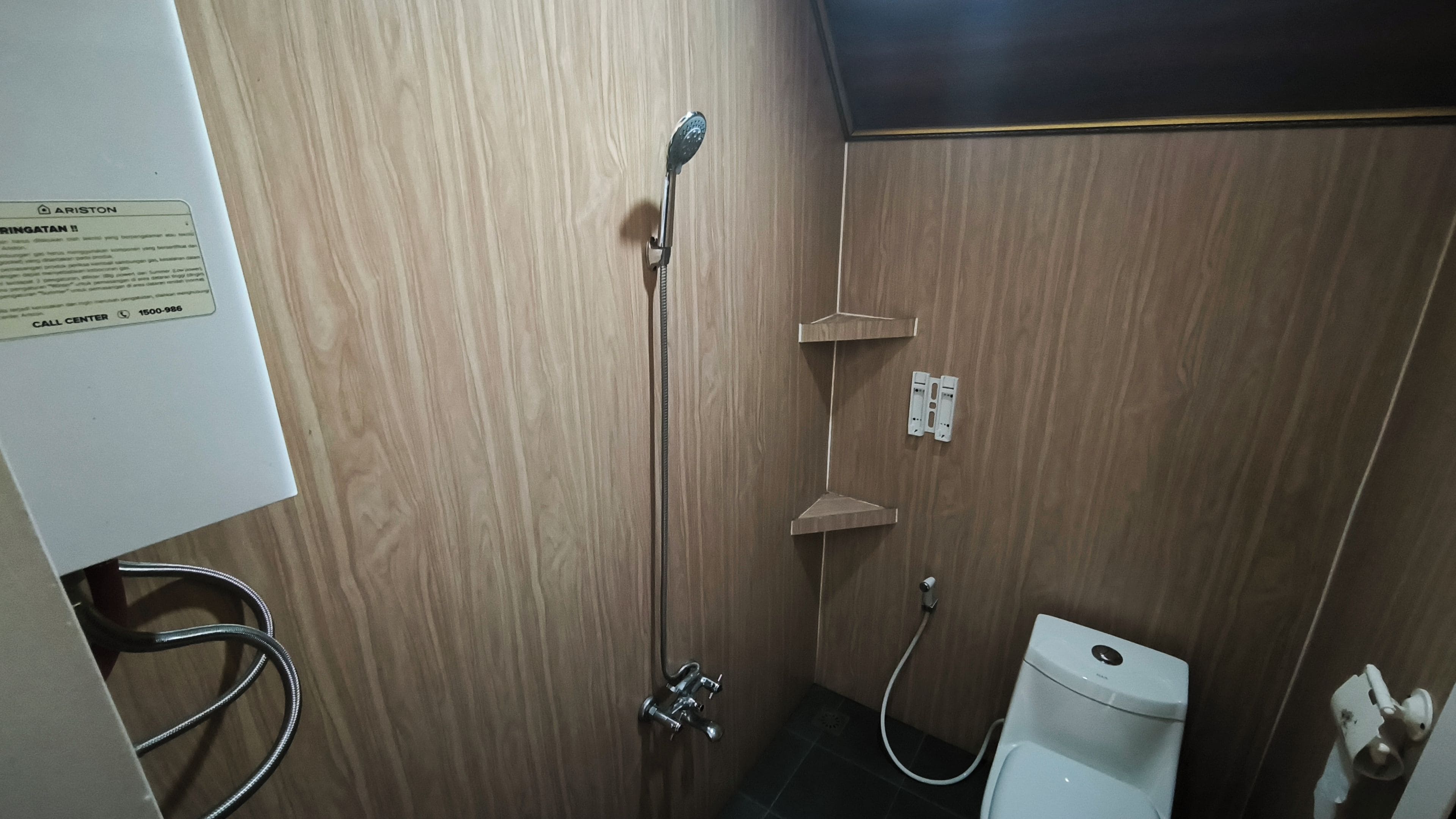 Un baño con ducha, inodoro y un letrero de centro de atención al cliente en la pared.