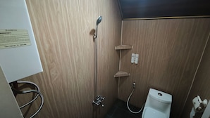 Casa de banho com chuveiro, sanita e um sinal de call center na parede.