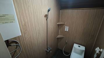 Un baño con ducha, inodoro y un letrero de centro de atención al cliente en la pared.