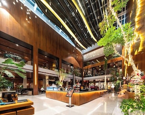 A spacious lobby with a central bar area, multiple seating options, and a high ceiling with exposed beams. - Huidong Business Hotel (Linyi)
