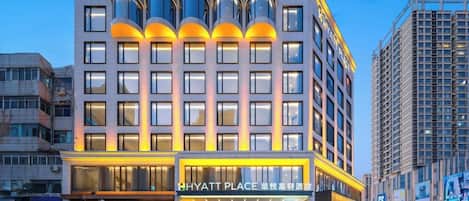 A multi-story hotel with a modern facade, large windows, and a prominent entrance.
