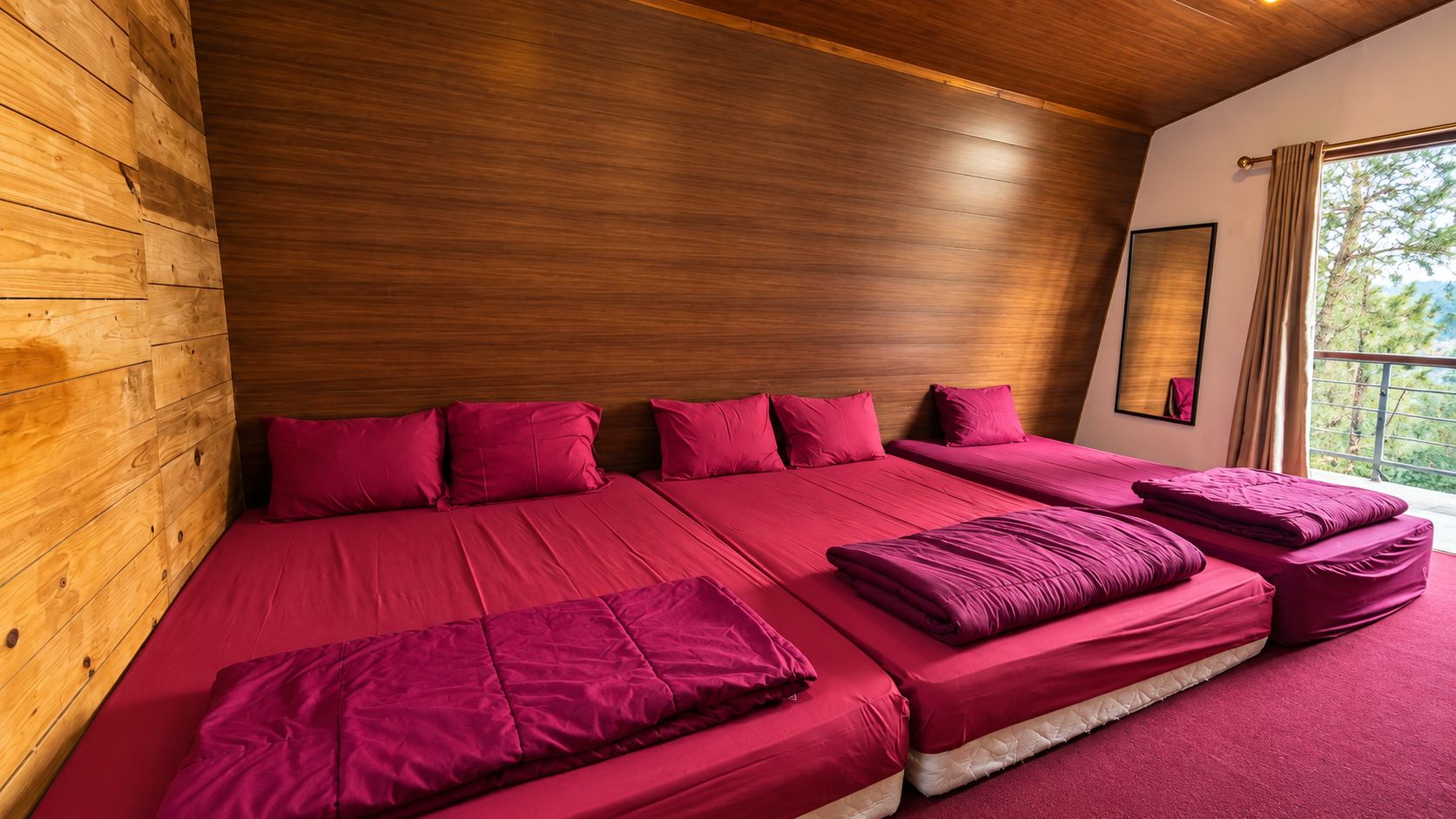 Una habitación con una cama grande, paredes de madera y una ventana con cortinas.