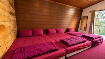 Una habitación con una cama grande, paredes de madera y una ventana con cortinas.